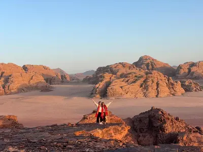 a person standing on a rock in the desert at Ruby Orbit Wadi Rum in Wadi Rum