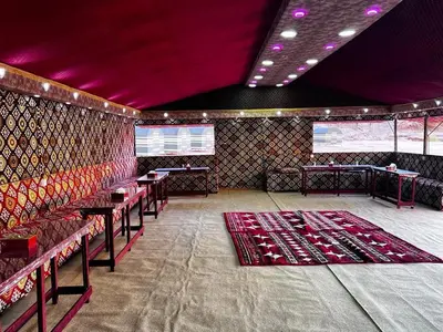 a room with tables and chairs and purple ceilings at Ruby Orbit Wadi Rum in Wadi Rum