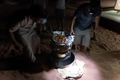 a group of people standing around a cake at Ruby Orbit Wadi Rum in Wadi Rum