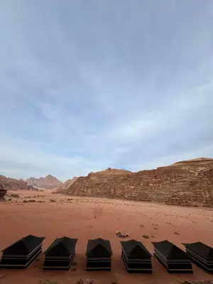 a row of black tents in the desert at Ruby Orbit Wadi Rum in Wadi Rum
