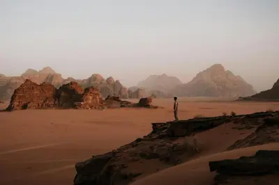 a man standing on a rock formations in the desert at Ruby Orbit Wadi Rum in Wadi Rum