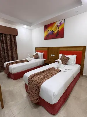 a hotel room with two beds and a painting on the wall at Petra Rocks Hotel in Wadi Musa