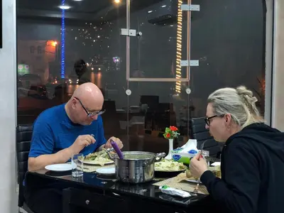 a man and a woman sitting at a table eating food at Petra Rocks Hotel in Wadi Musa