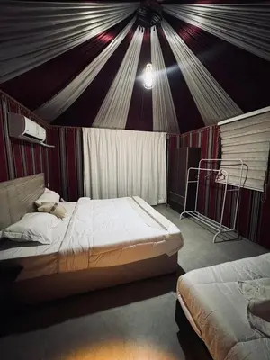 a bedroom with two beds in a tent at Wadi Rum Sand moon Camp &Tour in Wadi Rum
