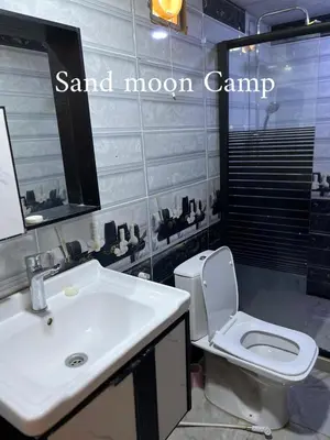 a bathroom with a sink and a toilet and a mirror at Wadi Rum Sand moon Camp &Tour in Wadi Rum
