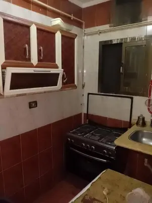 a kitchen with a stove and a sink at 77 apartment in Abū aş Şalīḩ