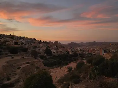 a view of a city from a hill at sunset at Petra Masterpiece in Wadi Musa