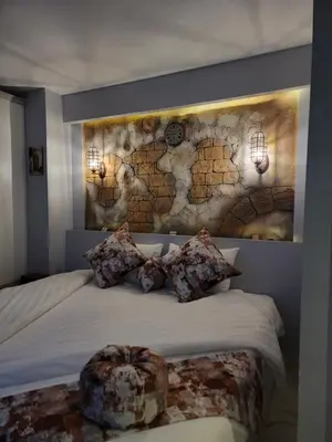 a bedroom with a bed with a stone wall at Petra Masterpiece in Wadi Musa