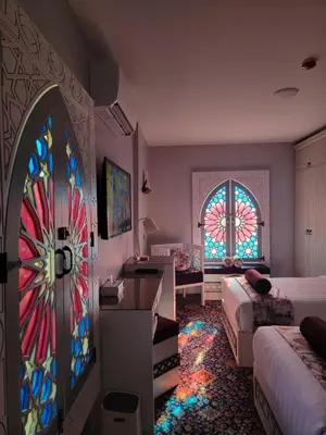 a bedroom with a door with a stained glass window at Petra Masterpiece in Wadi Musa