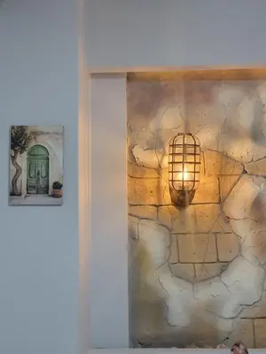 a room with a stone wall with a light on it at Petra Masterpiece in Wadi Musa