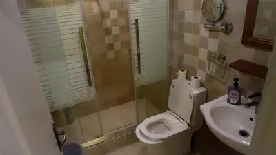 a bathroom with a shower and a toilet and a sink at Rafiki Hostel in Wadi Musa