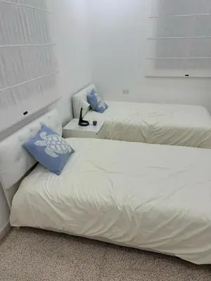 two beds sitting next to each other in a bedroom at Ahlam Apartments in Amman