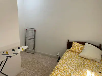 a small bedroom with a bed and a radiator at Ahlam Apartments in Amman