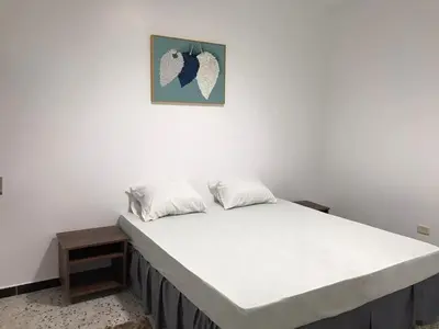 a white bed in a room with a picture on the wall at رزق هاوس in Ash Shūnah ash Shamālīyah