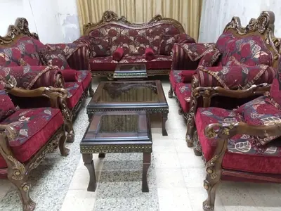 a living room with red couches and a coffee table at رزق هاوس in Ash Shūnah ash Shamālīyah
