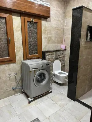 a washing machine in a bathroom with a toilet at رزق هاوس in Ash Shūnah ash Shamālīyah