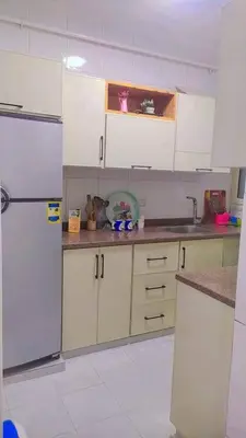 a kitchen with white cabinets and a refrigerator at رزق هاوس in Ash Shūnah ash Shamālīyah