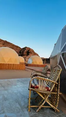 a chair sitting on the ground in a desert at Whispers of Night Camp in Jurf ad Darāwīsh