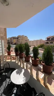 a balcony with a table and potted plants on it at Royal in Aqaba