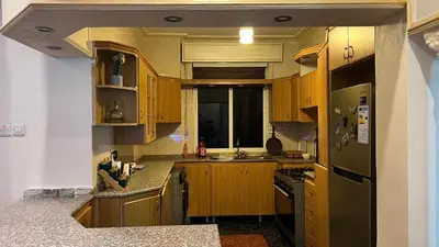 a kitchen with wooden cabinets and a refrigerator at Royal in Aqaba