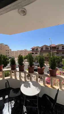 a table and chairs on a balcony with potted plants at Royal in Aqaba