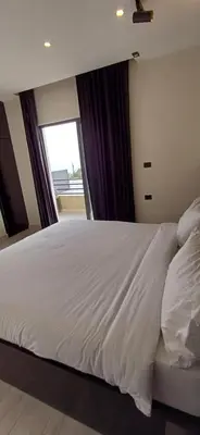 a bedroom with a large white bed with a window at LAVA Resort Hot spring water in Mukāwir
