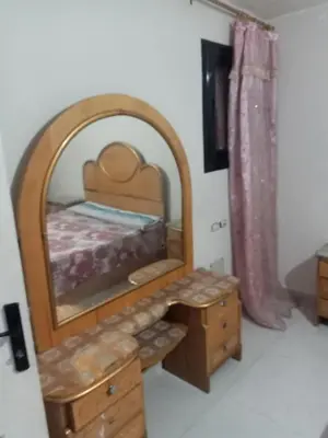 a bedroom with a bed with a mirror and a dresser at غباوي موتل in Az Zarqa