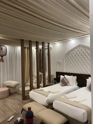 a hotel room with two beds and a table at مخيم خيال رم in Jurf ad Darāwīsh