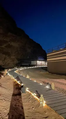 a long line of lights on a beach at night at مخيم خيال رم in Jurf ad Darāwīsh