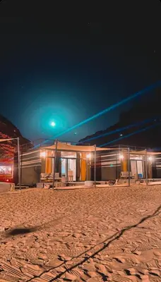 a building in the middle of the desert at night at مخيم خيال رم in Jurf ad Darāwīsh