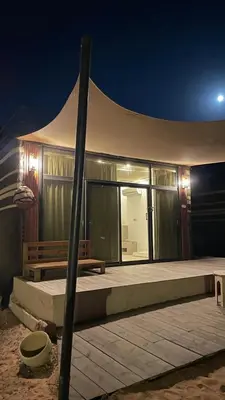 a tent with a bench in front of it at night at مخيم خيال رم in Jurf ad Darāwīsh