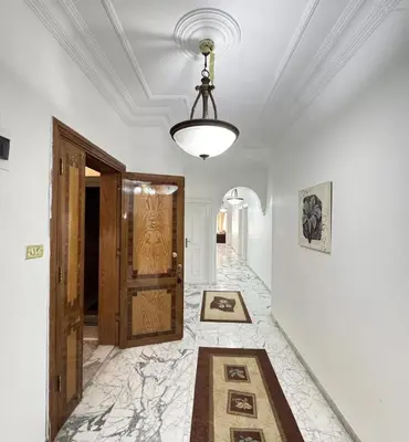 a hallway with a door and a chandelier at شقة مفروشة للايجار مميزه هادئه امنه ذات اطلاله رائعه in Amman