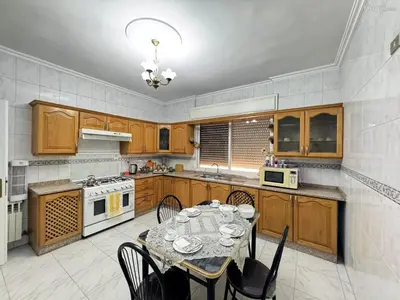 a kitchen with a table with chairs and a stove at شقة مفروشة للايجار مميزه هادئه امنه ذات اطلاله رائعه in Amman