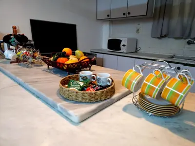 a kitchen with a table with baskets of fruit and plates at Cozy Home with a Lovely Garden in Jurf ad Darāwīsh