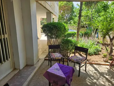 two chairs sitting on the porch of a house at Cozy Home with a Lovely Garden in Jurf ad Darāwīsh