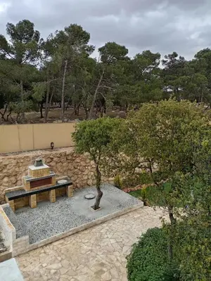 a picnic table and a tree in a garden at Munifah Grand Hills Chalet and Farm in Jurf ad Darāwīsh