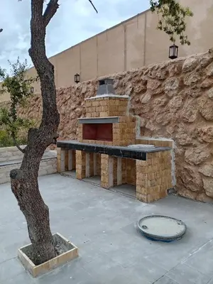a stone fireplace with a bench next to a stone wall at Munifah Grand Hills Chalet and Farm in Jurf ad Darāwīsh