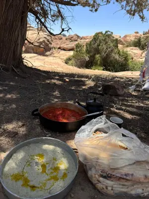 two pans of food on a table in the desert at Dana bedouin Sky in Dana