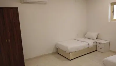 a small bedroom with a bed and a night stand at المناره ان in Amman