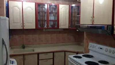 a kitchen with white cabinets and a stove top oven at المناره ان in Amman