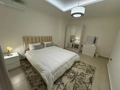 a bedroom with a large bed and a mirror at Cozy 3-Bedroom Apartment in Abdoun in Amman