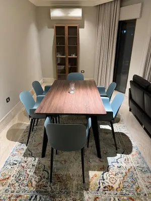 a conference room with a wooden table and blue chairs at Cozy 3-Bedroom Apartment in Abdoun in Amman
