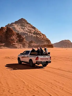 a group of people in a truck in the desert at في اصحراء المريخ في وادي رم in Jurf ad Darāwīsh