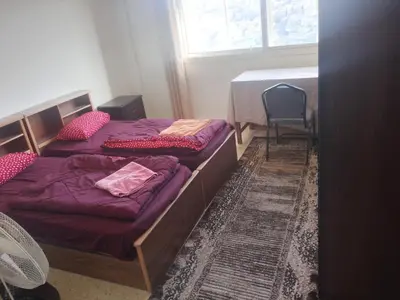 two twin beds in a room with a window at Sindbad Apartment in Jurf ad Darāwīsh