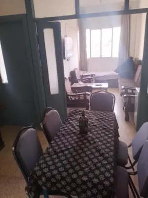 a room with a table and chairs and a living room at Sindbad Apartment in Jurf ad Darāwīsh