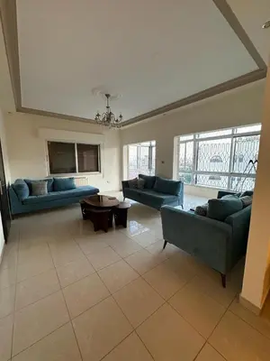 a large living room with couches and a table at Cosy family apartment in Amman in Amman