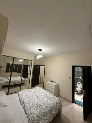 a bedroom with a white bed and a mirror at Cosy family apartment in Amman in Amman