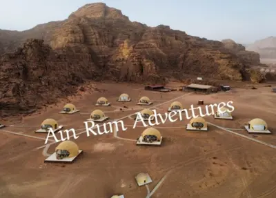 a group of tents in a desert with a mountain at مغامرات عين رم in Jurf ad Darāwīsh