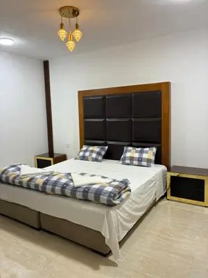 a bedroom with a large bed with a black headboard at Camel Dive Club By The Sea Inn in Jurf ad Darāwīsh