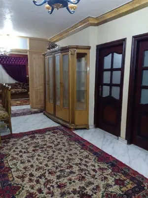 a room with a large rug and a wooden door at ام القطين لونج in Umm al Qiţţayn